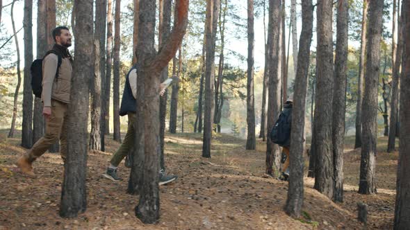 Side View of Husband Wife and Kid Hiking in Woods Holding Map Enjoying Travelling Outdoors