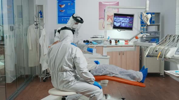 Dental Specialist with Coverall Speaking with Senior Patient
