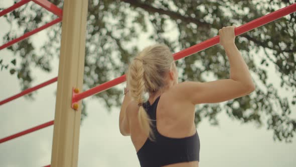 Fitness Sport Street Workout. Muscle Up In Public Gym. Healthy Woman On Pull-up Bars Exercising.