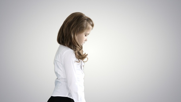 Little girl with long hair walking and looking down on