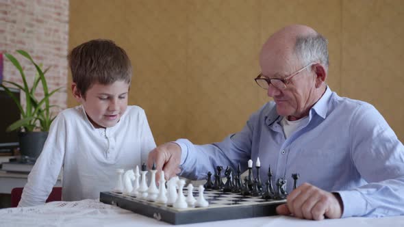 Intellect, Caring Intelligence Old Man with Glasses for Vision Plays Board Games with His Smart