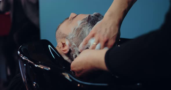 Hairdresser Shampooing Client's Hair a Lot of Foam on His Head