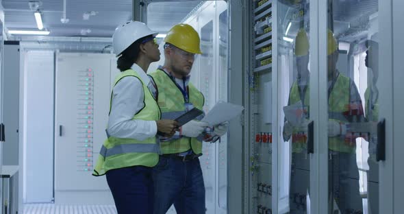 Two Electrical Workers Walking in the Control Room