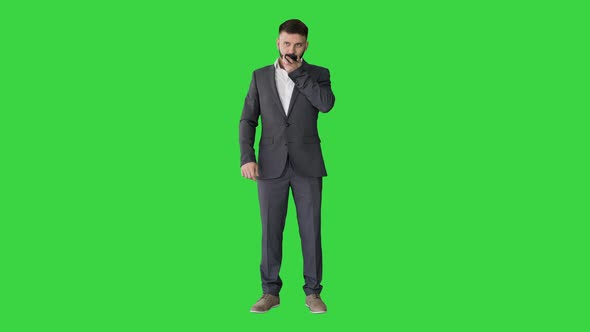 Businessman Using Speak Activate Virtual Digital Voice Assistant on Smartphone on a Green Screen