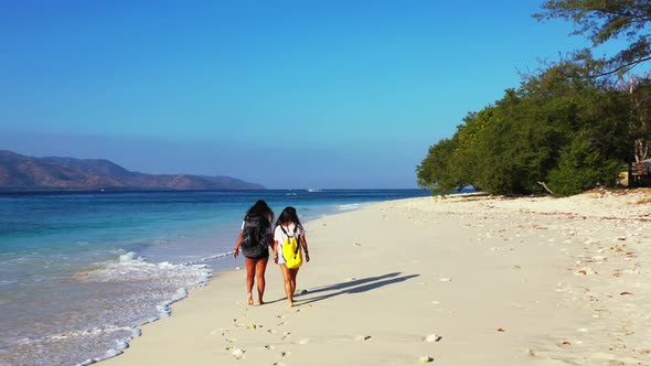 Girls tan on tranquil resort beach vacation by turquoise lagoon and white sandy background of Gili A