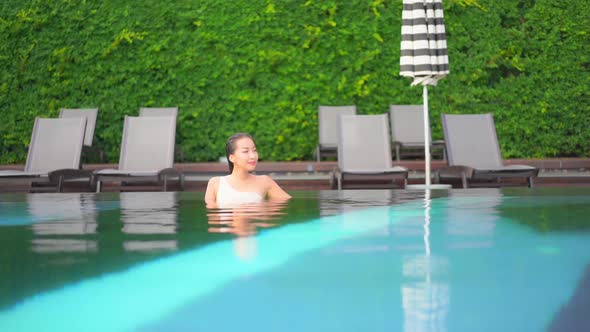 Young asian woman enjoy around outdoor swimming pool for leisure