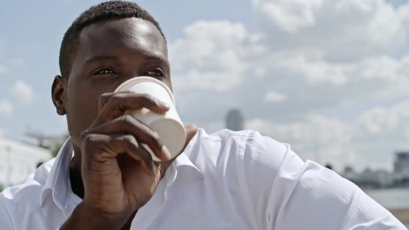 African Businessman Drinking Coffee Outdoors