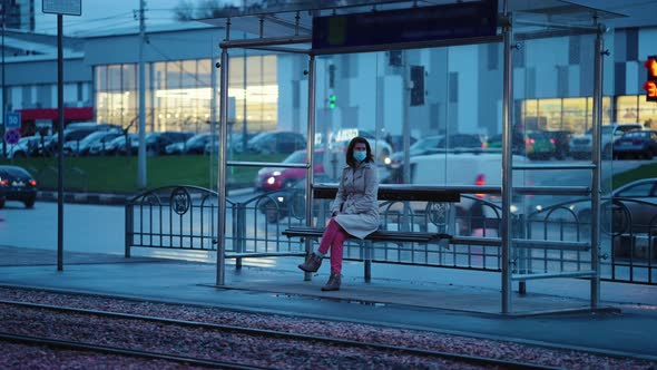 Lonely Woman at Tram Stop in the Evening