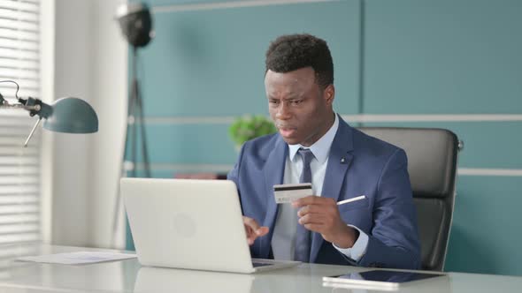 African Businessman Making Online Payment Failure on Laptop in Office