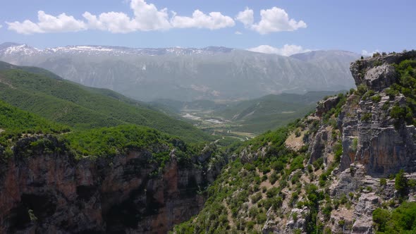 Aerial of Benje Canyon between huge green mountains of Permet Town.