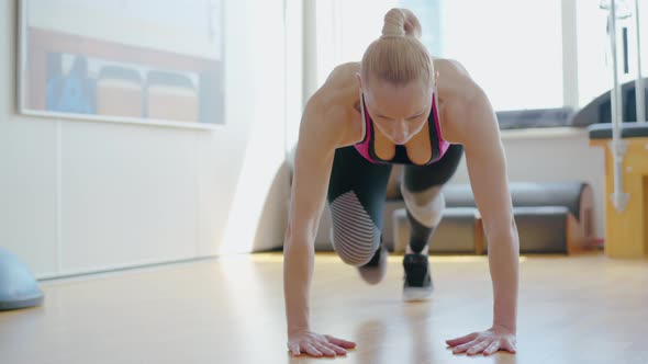 Confident Concentrated Sportswoman Doing Running Plank Exercise in Gym. Portrait of Athletic Blond