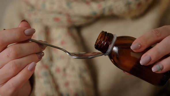 Female Hands Pouring Medicine From Bottle To Spoon