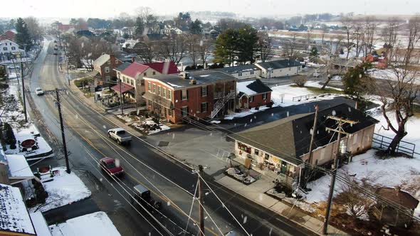 AERIAL Horse-Drawn Buggy Trotting Along Town Streets During Snowfall