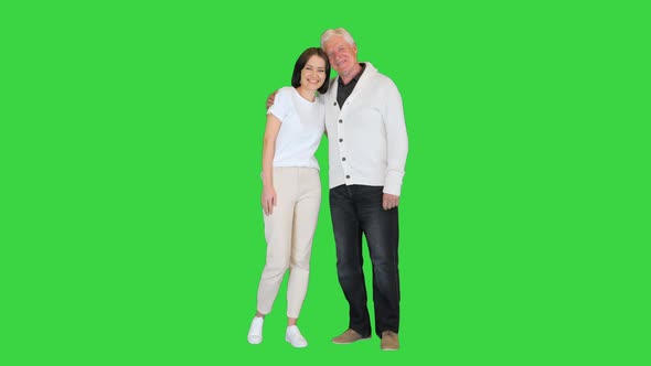 Adult Granddaughter and Elderly 80s Grandfather Smiling on Camera on a Green Screen Chroma Key