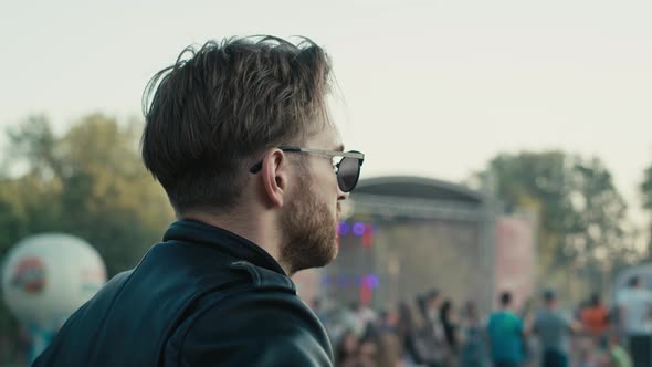 Rear view of  young caucasian man  on music festival looking at the stage. Shot with RED helium came