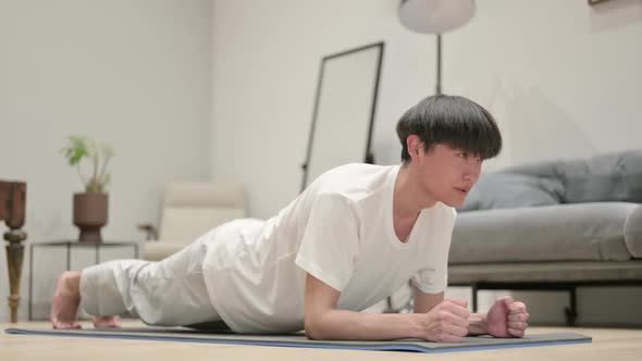 Asian Man Doing Plank on Yoga Mat at Home