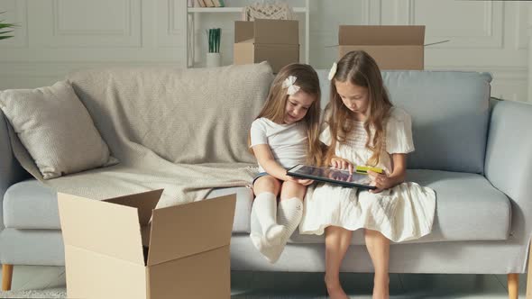 Two Children Working on a Laptop at Home Do Some Operation With a Credit Card