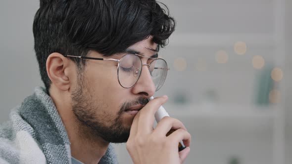 Closeup Arabian Indian Bearded Guy with Glasses Lonely Sad Sick Ill Man Wrapped in Blanket Spraying