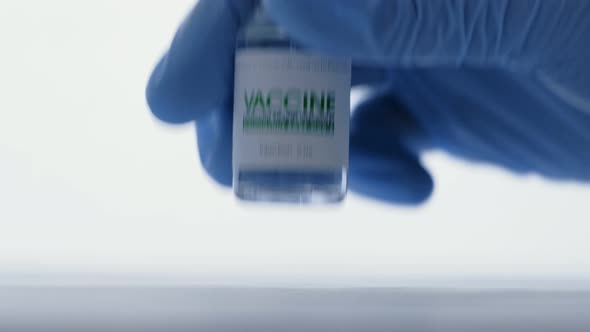 Doctor in Medical Glove Takes Vial of Vaccine for Injection for COVID19 Coronavirus Cure in Research