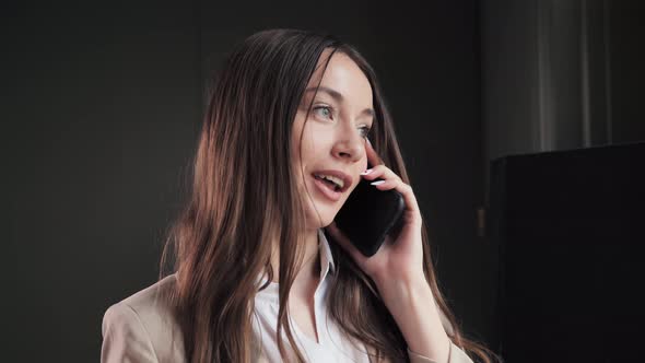 Closeup Positive Business Woman Talking on Smartphone in Hotel Room