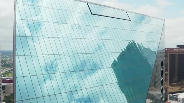 Sky and Surrounding Skyscrapers Reflecting in Tilted Glass Facade of Tall Building