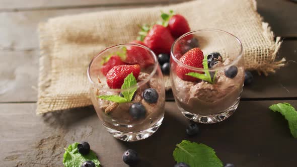 Video of chocolate pudding with strawberries and bluberries on a wooden surface