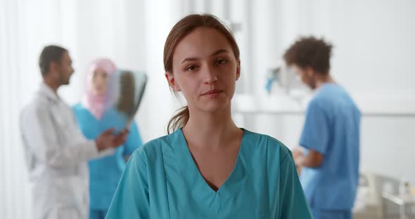 Portrait of Young Female Nurse Looking at Camera and Talking