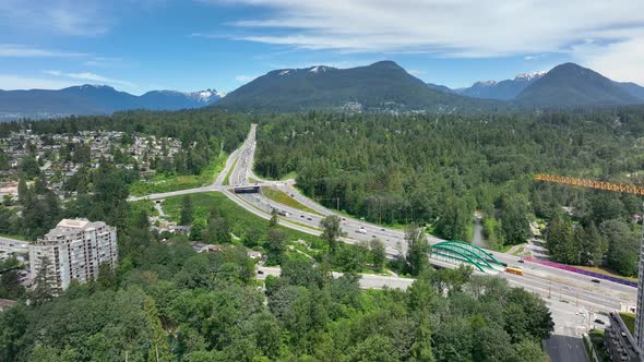 Cars Driving On Trans-Canada Highway With Mountain Views In The Background From Lynnmour, Canada. -