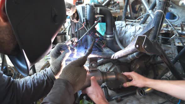 Mechanic in Protective Mask Welding Automobile Details. Repairer Fixing Auto. Men Working in Garage