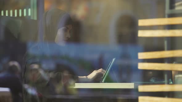 Attractive Lady in Hijab Working on Tablet, Sitting in Cafe, Freelance Project