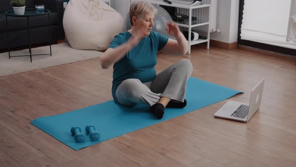 Old Person Looking at Video with Workout Lesson on Laptop