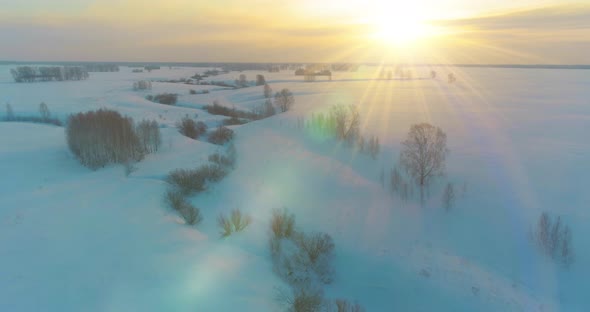 Aerial View of Cold Arctic Field Landscape Trees with Frost Snow Ice River and Sun Rays Over Horizon