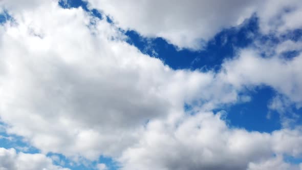 Time-lapse of fluffy clouds moving in the blue sky