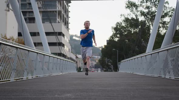 Sporty Caucasian man training on a bridge