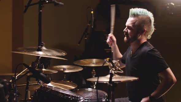 Drummer performing in a studio setting.