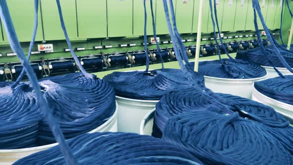 Factory Mechanism is Slowly Unwinding Strands of Cloth