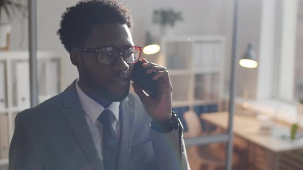 Young Black Businessman Talking on Cell Phone in Office