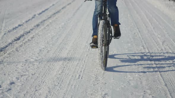 Man Riding Bike on a Snowy Day Slippery Road Conditions