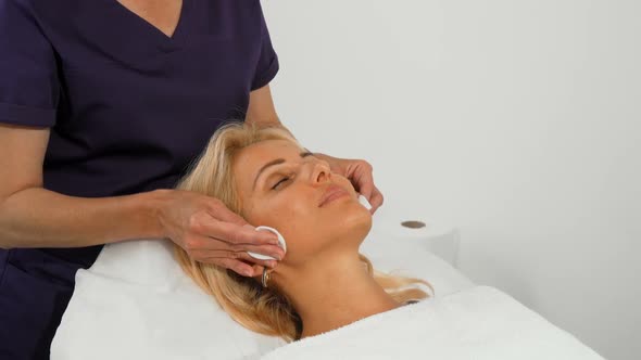 Mature Woman Getting Facial Cleanse Treatment By Cosmetologist