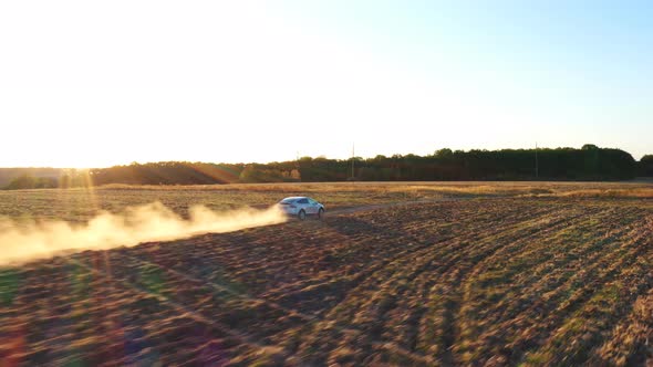 Aerial Shot of Electrical Car Moving on Off-road Route Leaving Dust Trail Behind. New Auto Driving