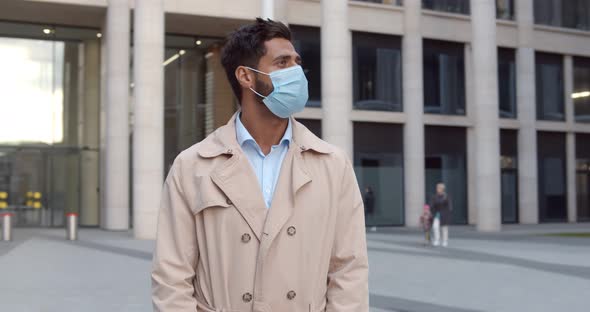 Confident Businessman Standing Outdoors Against Business Center Wearing Protective Face Mask