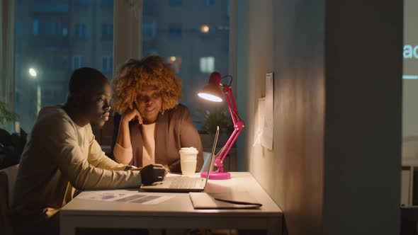 African American Man and Woman Working Late in Office