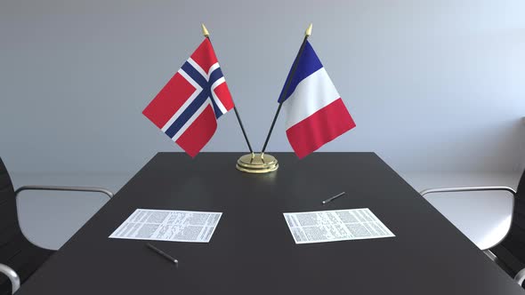 Flags of Norway and France and Papers on the Table alt