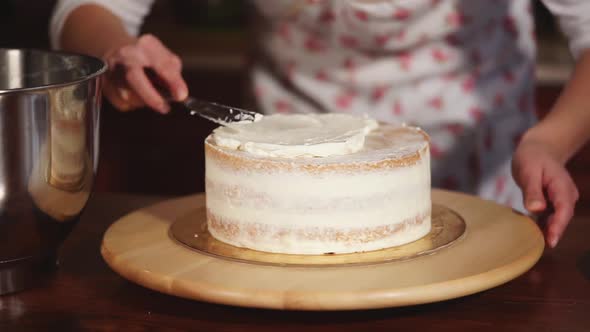 Housewife Is Decorating Sweet Cake By Creamy Cream, Putting on a Top