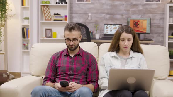 Beautiful Couple Sitting on the Couch and Doing Online Shopping
