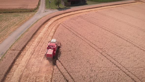 Combine working on large wheat field