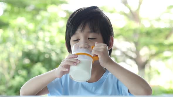 Cute Asian Child With A Glass Of Milk And Licking Lip Slow Motion