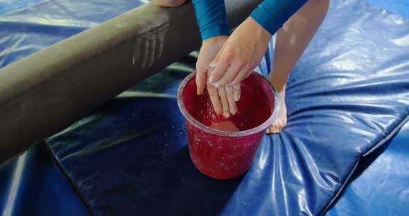 Gymnast putting chalk powder on her hands