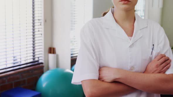 Female physiotherapist standing with arms crossed in clinic 4k