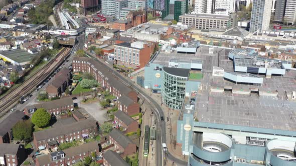 Dolly back pan up reveal drone shot from tram to Croydon town London